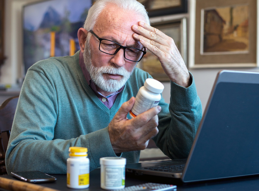 Senior ill man taking pills from the bottle at home